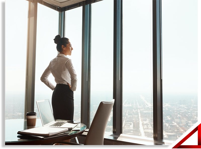 Woman looking out office window in highrise